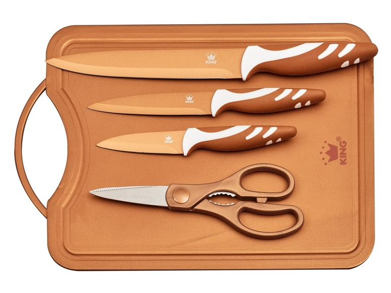 Ein Set mit drei King Messern und einer Schere auf einem kupferfarbenen Schneidebrett.