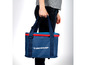 Eine Person trägt eine blaue Dunlop Kühltasche.
