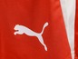 Ein rotes Kleidungsstück mit einem weißen Puma-Logo.