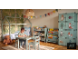 Kinderzimmer mit Hausbett, Tisch und Stühlen, Bücherregalen und Waldmotiv-Kleiderschrank.