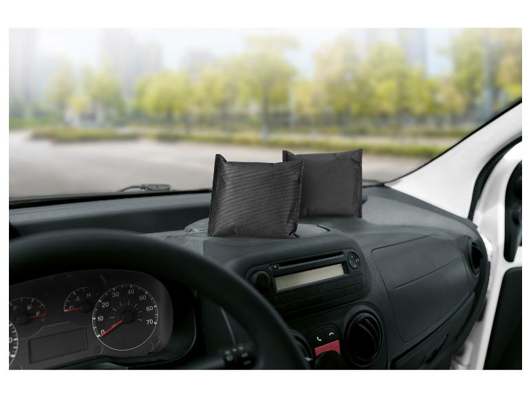 Zwei schwarze Feuchtigkeitsabsorber auf dem Armaturenbrett eines Autos.