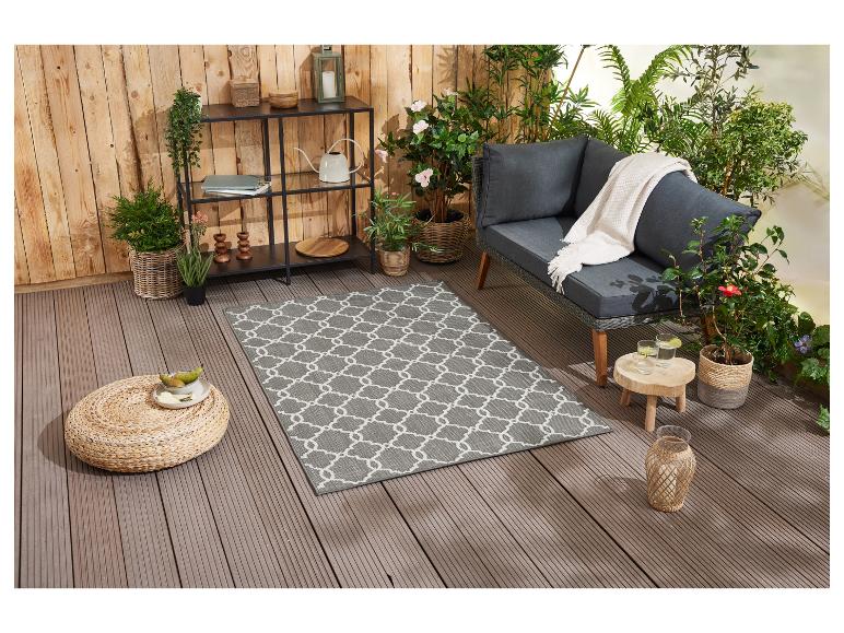 Grauer Outdoor-Teppich mit geometrischem Muster, Gartenmöbel und Accessoires.
