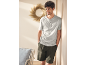 Lächelnder Mann in einem hellgrauen Henley-Shirt und dunkelgrünen Shorts.