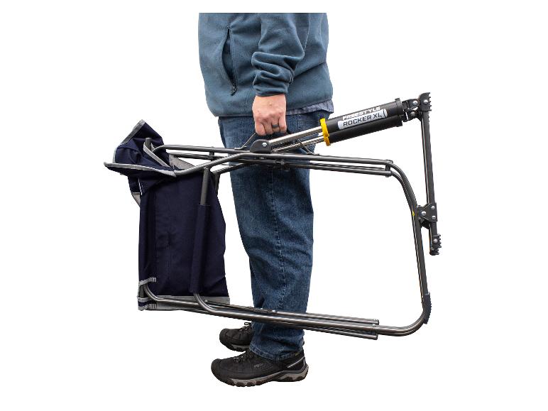 Ein Mann trägt einen Freestyle Rocker XL Campingstuhl.