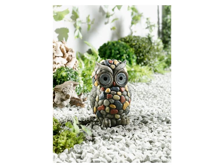 Eine Steinhöhle mit solarbetriebenen Lichtern in einem Garten.