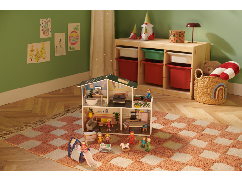 Puppenhaus mit Möbeln und Puppen auf einem karierten Teppich im Kinderzimmer.