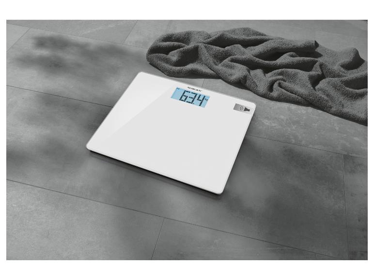 Weiße SilverCrest Personenwaage mit digitalem Display und Handtuch.