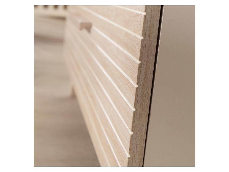 Nahaufnahme eines hellen Holzschranks mit horizontalen Rillen und einem kleinen Griff.