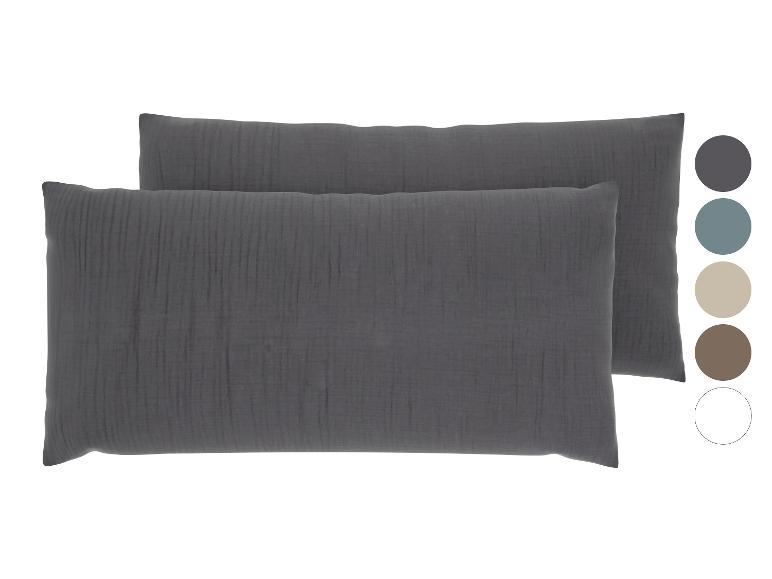 Zwei dunkelgraue strukturierte Kissen und Farbmuster.