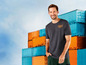 Mann in einem grauen T-Shirt mit 'Workhard'-Logo vor einem Container-Hintergrund.