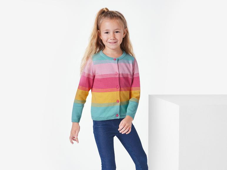 Ein Mädchen trägt einen gestreiften Pullover und blaue Jeans.