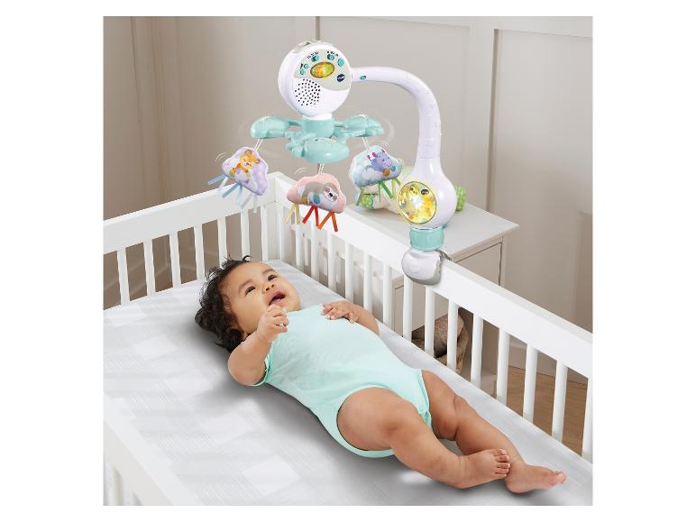 Baby liegt im Kinderbett, darüber ein Mobile mit Tierfiguren und Lichtern.