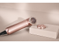 Roségoldener Elektrorasierer mit abnehmbarem Kopf auf einer hellen Oberfläche.