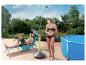 Frau duscht und Mann entspannt auf Liegestuhl am Pool, an einem sonnigen Tag.