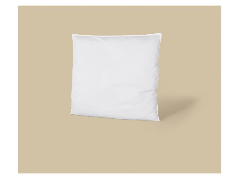 Weißes Kissen auf beigem Hintergrund