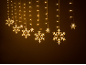Warmweiße Schneeflocken-Lichterketten auf dunklem Hintergrund.