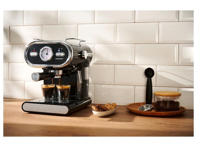 Schwarze Espressomaschine brüht zwei Kaffees, mit Keksen und Kaffeebohnen.