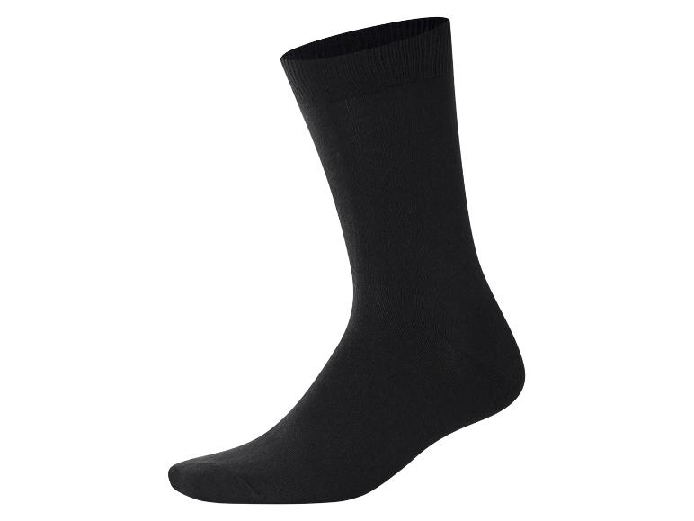 Eine schwarze Socke steht vertikal auf weißem Hintergrund.