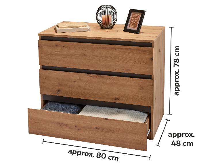 Holzkommode mit drei Schubladen, eine offen, mit Kerze und Bilderrahmen oben.