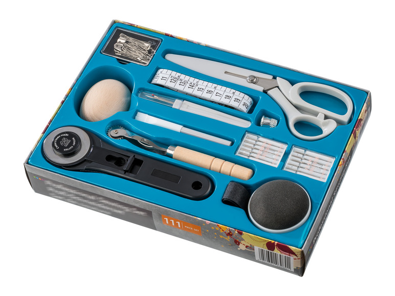 Ein Nähset mit einem Rollschneider, einer Schere und Stecknadeln.