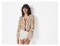 Modell in beige Lochmuster-Cardigan und weißer Shorts.