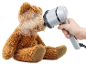 Dampfglätter frischt den Stoff eines braunen Teddybären auf.