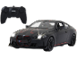 Schwarzes ferngesteuertes Spielzeugauto mit leuchtenden Scheinwerfern und Fernbedienung.