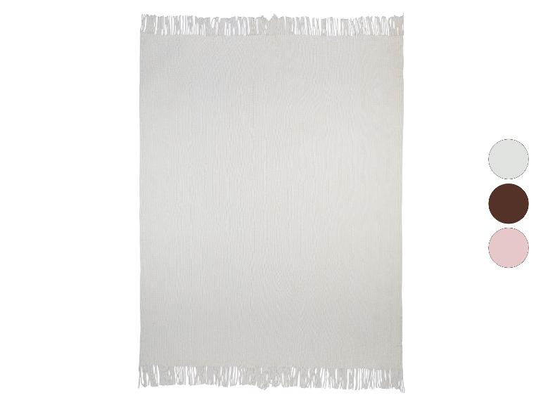 Weiche, cremefarbene Strickdecke mit Fransen.