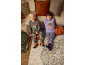 Zwei lächelnde Kinder in Halloween-Pyjamas, auf einem Teppich neben einem Sofa sitzend.