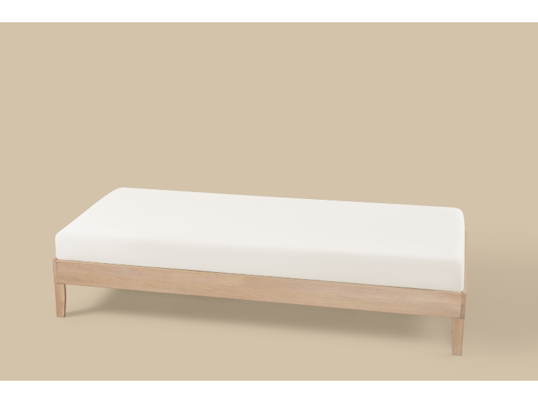 Helle Holzbank mit weißem Kissen auf beigem Hintergrund.