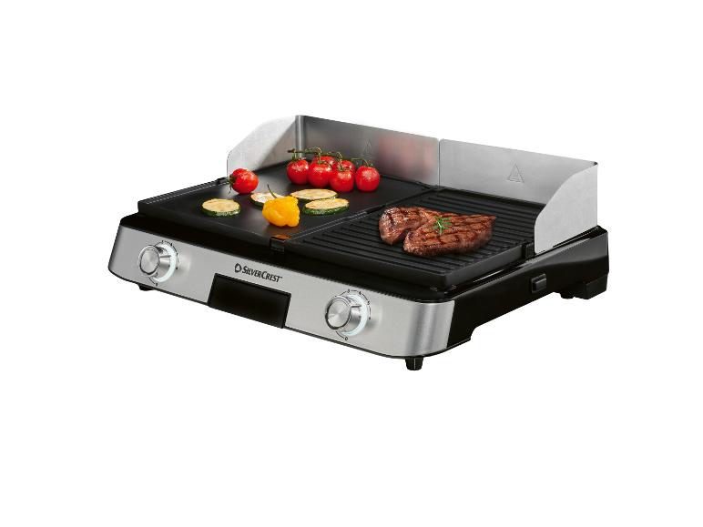 Elektrischer Grill mit flacher und geriffelter Oberfläche, mit Steak, Tomaten und Zucchini.