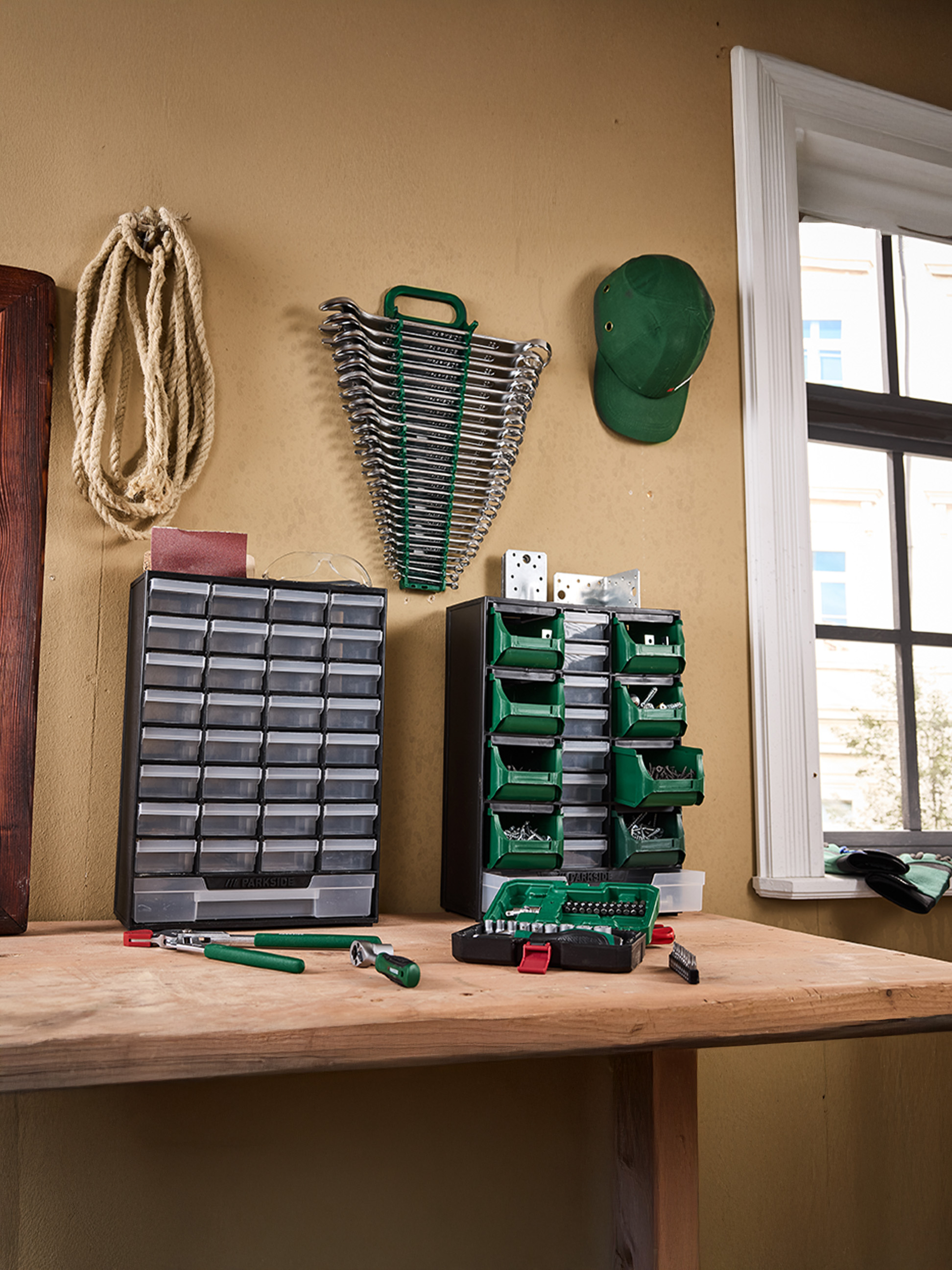 PARKside Werkzeuge und Organizer auf einer Werkbank, inklusive Schraubenschlüssel, Schrauben und Bits.