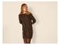 Frau in braunem Strickkleid und schwarzer Strumpfhose, blickt zur Seite.