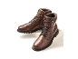 Ein Paar braune Leder-Herrenstiefel mit Schnürsenkeln und Reißverschlüssen, auf weißer Plattform.