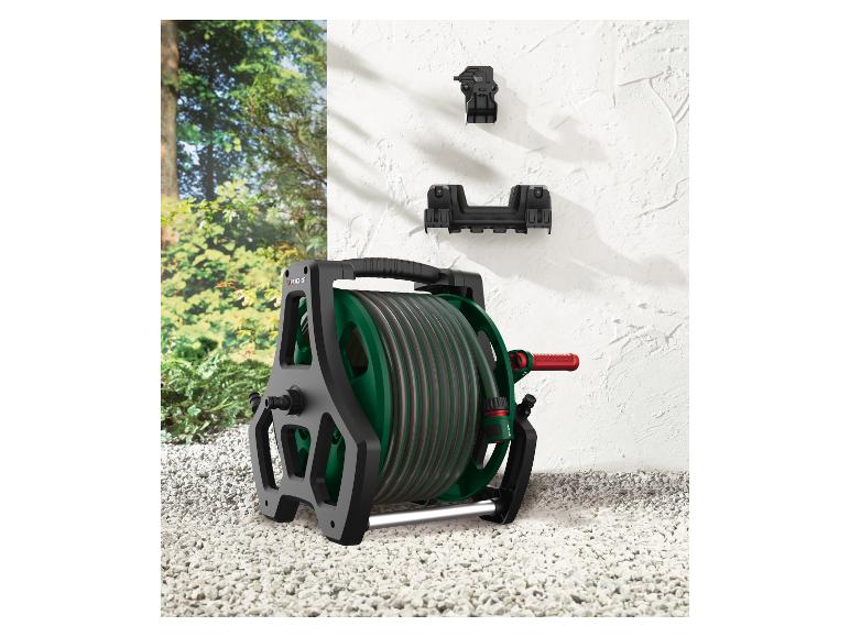 Parkside Gartenschlauchwagen mit Schlauch und Wandhalterungen auf Kiesuntergrund.