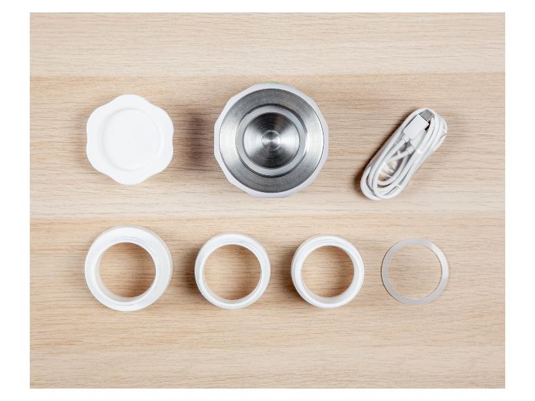 Gesichtspflegeset mit Massagegerät, Ringen und USB-Kabel.