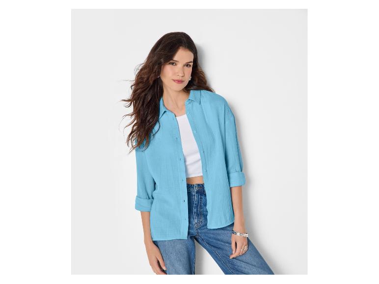 Frau in hellblauem Hemd, weißem Top und blauen Jeans