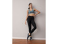 Eine Frau in schwarzen Leggings und einem blauen Sport-BH.