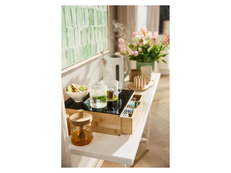 Bambus-Serviertablett mit Tee, Wasserkocher und Keksen.