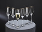 Ein Champagnerglas mit goldenem Rand, umgeben von leeren Gläsern.