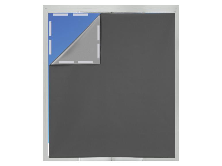 Dunkelgraues Rollo mit hochgezogener Ecke, das die silberne Rückseite und das blaue Fenster zeigt.
