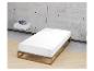 Bett mit Holzrahmen und weißer Matratze, mit schwebendem Regal und Büchern.