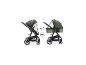 Zwei grüne Kinderwagen mit Moskitonetz, einer als Sportwagen, der andere mit Babywanne.