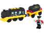 Spielzeugeisenbahn mit schwarzer Lokomotive, gelbem Unterbau und schwarzem Tankwagen, mit einer Schaffnerfigur.