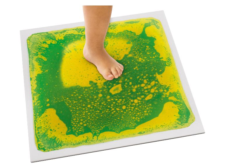 Kinderfuß tritt auf eine sensorische Platte mit grüner und gelber Flüssigkeit