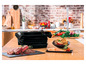 Gegrilltes Steak, Lachs und Gemüse auf einem Holztisch, neben einem schwarzen OptiGrill Elite Grill.