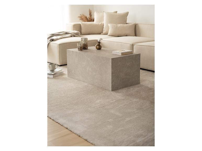 Wohnzimmer-Interieur: beiges Modulsofa, Couchtisch in Marmoroptik und heller Teppich.