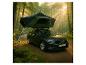 Auto mit Dachzelt in einem sonnigen Wald.