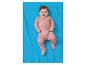 Lächelndes Baby in rosa Strampler mit Bärenmuster, liegend auf einer blauen Decke.