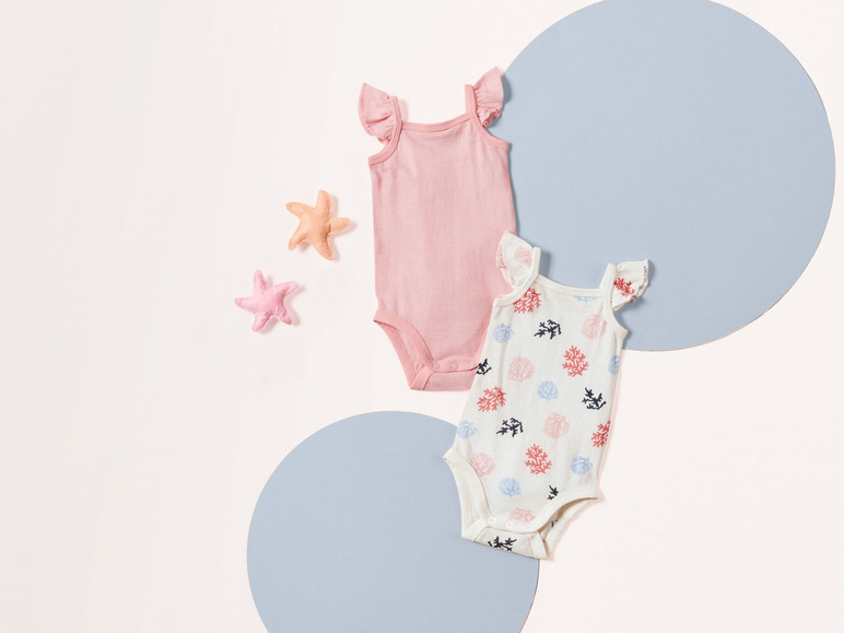 Zwei Babybodys mit Meeresmotiven, ein rosafarbener und ein Korallenmuster.